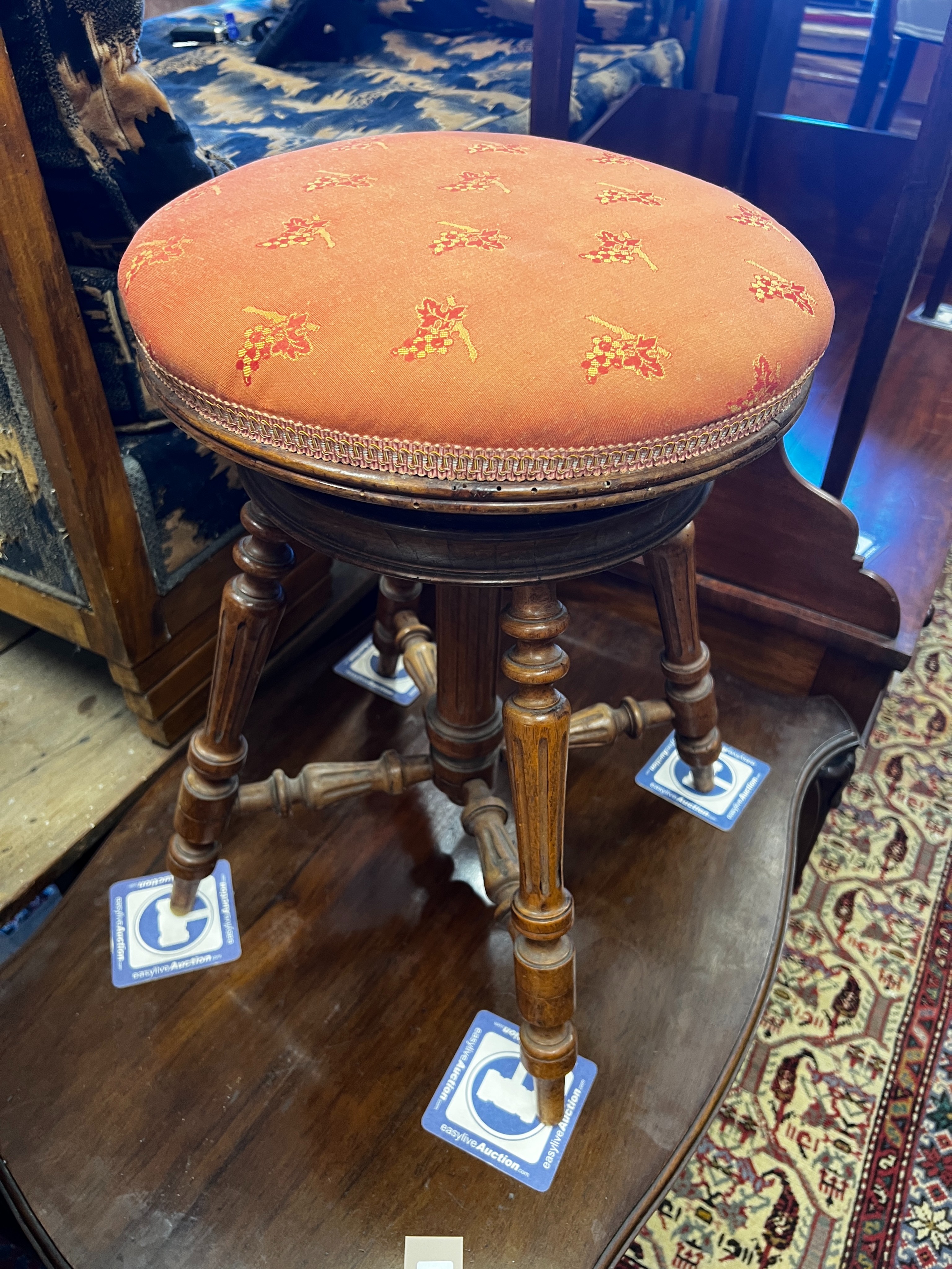 A late 19th century French walnut revolving adjustable piano stool and a Victorian mahogany centre table